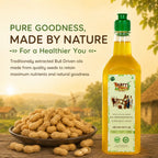 Nandi's Blessing pure bull-pressed groundnut oil glass bottle displayed beside raw peanuts.